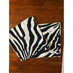 two black and white zebra print scarves sitting on top of a wooden floor