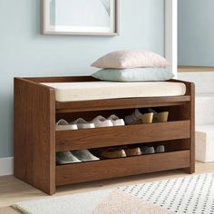 a wooden shoe rack with shoes on it in front of a stair case and rug