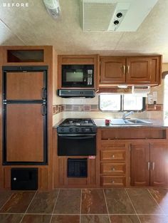 an rv kitchen with wood cabinets and black stove top oven in the middle of it