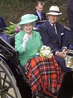 the queen and prince are riding in a horse - drawn carriage with two men on either side