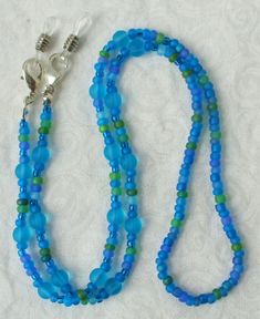 You'll always know where your eyeglasses are when you use this light blue beaded eyeglass chain! 26.5" in length, made with glass beads, beading cord, metal lobster clasps, and adjustable rubber holders. Lobster clasps make it easy to change the rubber holders, and an extra pair of holders included with every purchase. This light blue beaded eyeglass chain will arrive in a gift box, ready to give as a present or to keep and store. Back to Beaded Eyeglass Chains Blue Beaded Chain Glasses Chains With Round Beads, Blue Beaded Glasses Chains, Blue Glasses Chains With Round Beaded Chain, Blue Beaded Glass Glasses Chains, Adjustable Czech Glass Beaded Necklaces With Lobster Clasp, Blue Beaded Jewelry For Everyday Use, Everyday Blue Beaded Jewelry, Adjustable Blue Glasses Chains With Colorful Beads, Adjustable Beaded Plastic Jewelry