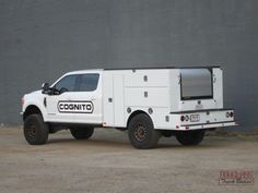 a white truck parked in front of a gray wall with the words cognito on it