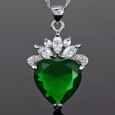 Stunning Heart Cut Fine Emerald Cubic Zirconia With Clear Cubic Zirconia Embellishments (19mm X 28mm). The Stone Setting And Chain Are A Beautiful 18k White Gold Plating. Happy Shopping! Heart Cut Cubic Zirconia Jewelry For May Birthstone, Silver Heart Cut Necklace For May Birthstone, Green Cubic Zirconia Heart Cut Jewelry, Silver Jewelry With Heart Charm For May Birthstone, Collar Verde, Xmas Fashion, Jewelry Heart, Blue Pendant, Green Necklace