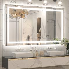 a bathroom with a sink, mirror and lights on the wall above it's counter