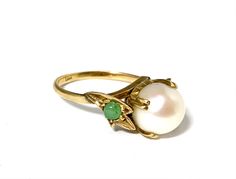 The center pearl of this special ring is an 8.5mm round creamy white cultured pearl with excellent luster. It is accented on either side with a 3mm jade cabochon, set into a leaf motif edged with milgrain. The ring is 18K yellow gold and weighs 3.1 grams.  Size 5.5.  It can be sized. Please get in touch with any questions you may have - I am here to help! We have been in the jewelry business in Arizona for over 30 years. We have many pieces in our brick and mortar store not listed here, so please get in touch if you are looking for something special. And check back to our Etsy shop - we are always adding new pieces! Elegant Green Pearl Ring With Gemstone, Elegant Green Gemstone Pearl Ring, Leaf Motif, Special Ring, Etsy Gold Ring, Jade Ring, Brick And Mortar, 18k Yellow Gold Ring, Yellow Gold Ring