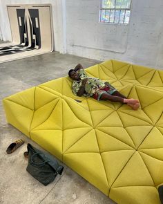 a man laying on top of a yellow mattress