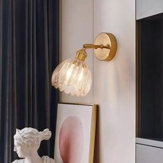 a wall light that is on the side of a wall next to a framed photo