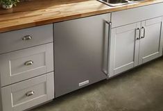 a kitchen with stainless steel appliances and wood counter tops on top of the cabinets is shown