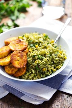 a white bowl filled with rice and fried plantains on top of a blue and white napkin