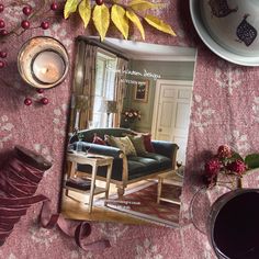 a living room filled with furniture and decor on top of a pink table cloth covered floor