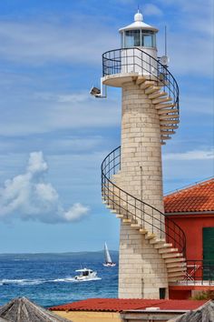 a lighthouse with a spiral staircase next to the ocean