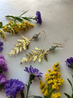 These hammered fern earrings feature faceted fluorite stones in a beautiful spring green color. The ferns are polished brass and lightweight. The wire used to wrap the stone is stainless steel. The earring hooks are stainless steel. Gold Nature-inspired Earrings With Natural Stones, Nature-inspired Gold Earrings With Natural Stones, Gold Nature-inspired Metal Earrings, Gold Natural Stones Earrings Nature-inspired, Dainty Hypoallergenic Brass Jewelry, Brass Jewelry With Birth Flower For Gift, Gold Leaf Nature-inspired Jewelry, Nature-inspired Leaf Jewelry Gift, Nature-inspired Gold Leaf-shaped Jewelry