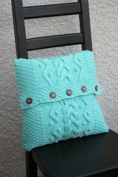 a blue pillow sitting on top of a wooden chair