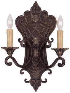 an ornate wall light with two candles on it