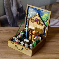 a small wooden box filled with figurines on top of a table