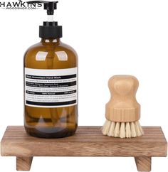 a wooden stand with a soap dispenser on it and a brush next to it