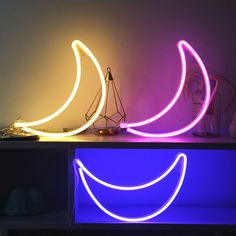 three neon lights sitting on top of a table next to a banana shaped sculpture and lamp