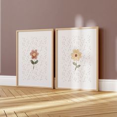 two framed pictures with flowers in them on the wall next to a hardwood flooring area