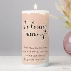 a pink candle with the words an loving memory printed on it next to a flower