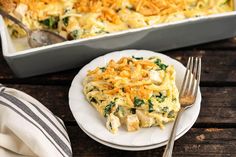 a casserole dish with chicken, spinach and cheese on a white plate