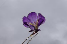 Purple Crocus Hair Pin Glass-like resin flower accessory This Purple Crocus hair pin crafted from transparent resin, the flower glass-like with a delicate, shimmering effect but incredibly lightweight. At the center of crocus flower is swarovski crystal. The flower stamen, also made from resin with crystals. The metal hairpin base in a golden color is rounded to naturally fit the shape of the head, making it easy to hide within your hair and comfortable to wear throughout the day.  Flower size 2 inches (5.5 cm) in diameter and height. This unique accessory won't weigh your hair down, ensuring you stay stylish and comfortable. Perfect as a special gift or a statement piece for both everyday wear and special occasions. Dimensions: Flower diameter: 2 inches (5.5 cm) Flower height: 2 inches (5 Purple Crocus, Flower Hairpin, Flower Stamen, Crocus Flower, Floral Accessories Hair, Transparent Resin, Kanzashi Flowers, Flower Resin, Metal Flower