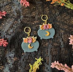 Calling all witches! These adorable floral cauldron earrings are the perfect addition to your witchy wardrobe. Glittery cauldrons adorned with flowers and a shiny resin coated moon. 🌙 Resin Coating, Halloween Earrings, Witch, Jewelry Earrings Dangle, Etsy Earrings, Dangle Drop Earrings, Dangle Earrings, Jewelry Earrings, Drop Earrings