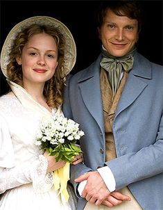 three people standing next to each other in front of a window wearing hats and gowns