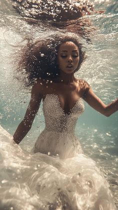 a woman in a white dress is under the water with her hair flying up and down