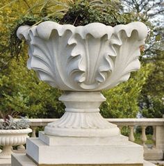 a large white planter sitting on top of a cement pedestal