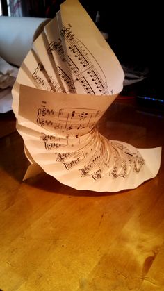 several sheets of paper with musical notes on them sitting on a wooden table in front of a computer