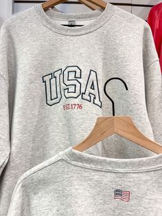 Our USA crew is perfect for the 4th of July! "Tomorrow" embroidered on back corner. 50% cotton, 50% polyester Medium-heavy fabric Letter Embroidery Crew Top For Streetwear, Cotton Campus Top With Letter Embroidery, Cotton Tops With Letter Embroidery For Campus, Cotton Varsity Crew Sweatshirt, Crew Neck Tops With Embroidered Graphics For Campus, Crew Neck Embroidered Graphics Tops For Campus, Cotton Crew Sweats For College, Embroidered Graphics Crew Neck Top, Cotton Sweatshirt With Letter Embroidery For Campus