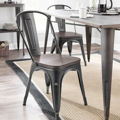 a dining room table and chairs with a rug on the floor in front of it