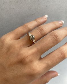 a woman's hand with a diamond ring on her left hand and two diamonds in the middle