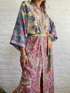 "This is one of a kind patchwork, upcycled silky robe Made free size with wrap tie closing and wide kimono sleeves  Easy and fun to wear around the house or outside as a urban boho style,  flowy kardigan with jeans and tshirt  It is very comfy and feels soft and light  the material is colourful indian saree silk made into this unique stylish over all MEAESURE free size length 55\" MATERIAL *polyester *no lining more available at  https://www.etsy.com/shop/AltheaStores? CARE INSTRUCTIONS  * Wash Multicolor Kimono With Tie Waist And Kimono Sleeves, Multicolor Silk Kimono For Beach Cover-up, Hippie Multicolor Kimono With Kimono Sleeves, Multicolor Hippie Kimono With Kimono Sleeves, Bohemian Multicolor Robe For Festivals, Hippie Multicolor Open Front Kimono, Beach Kimono With Patchwork Sleeves, Bohemian Long Kimono With Tie Waist, Hippie Style Multicolor Wrap Kimono