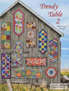 a book cover with an old barn and quilts on the front, along with a sign that says trendy table 2