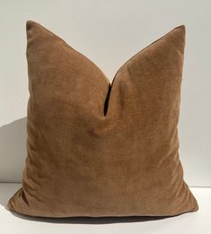 a brown pillow sitting on top of a white table