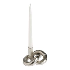 a white candle sitting on top of a metal holder with two rings attached to it