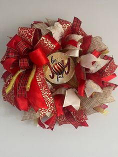 a red and gold christmas wreath with the word joy on it