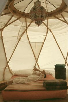 a person laying on top of a bed in a tent