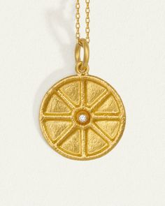 This divine necklace showcases the Star of Ishtar, symbolising love, passion and beauty. A raised rim encircles the large coin pendant that glows with the light of a natural diamond at its heart.  
 Crafted from softly textured 24k solid gold, this diamond pendant exudes a rich, tactile lustre that enhances its ancient allure. A 14k yellow gold curb chain completes this piece. Amulet Style Yellow Gold Medallion Necklace, Symbolic Yellow Gold Coin Medallion Necklace, Yellow Gold Medallion Necklace With Coin Pendant, Luxury Yellow Gold Coin Medallion Necklace, Yellow Gold Amulet Medallion Pendant Necklace, Yellow Gold Coin Necklace With Moon Charm Medallion, Yellow Gold Medallion Coin Necklace With Moon Charm, Symbolic Yellow Gold Coin Pendant Necklace, Spiritual Yellow Gold Coin Necklace With Large Pendant