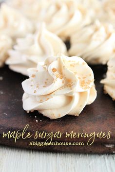 some white frosted cupcakes on a wooden board