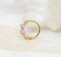 a gold ring with pink beads on it