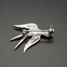 A charming vintage 835 silver pin, decorated with sparkling marcasite crystals. This dainty mid century 1950's brooch is featuring a small bird, a swallow. Would add a nice accent to any outfit. The brooch will be shipped in a gift box. The brooch measures 1 1/5 Inches wide by 9/10 inches tall (3.0 cm x 2.3 cm) Weight: 2.7 grams Hallmarked for 835 silver Rollover clasp Excellent vintage condition, with lovely patina. The standard shipping for this item is with tracking. If you prefer a faster sh Mid-century Silver Brooch For Collectors, Mid-century Silver Brooches For Collectors, Vintage Sterling Silver Brooch For Wedding, Vintage Sterling Silver Brooches For Wedding, Vintage Sterling Silver Wedding Brooches, Retro Silver Brooch Pin, Silver Retro Brooch Pin, Vintage Silver Lapel Pin For Anniversary, Mid-century Silver Jewelry With Brooch