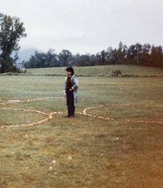 a man standing on top of a lush green field