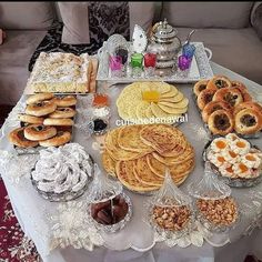 a table topped with lots of pastries and desserts