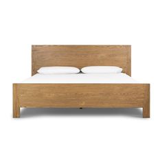 a wooden bed frame with white pillows on it