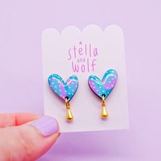 This version of the wonky heart drop earring has been hand painted in a modern abstract design using pretty pastel colours of emerald green, turquoise and pink with pale pink polka dots.  To finish the look a cute gold plated tear drop hangs from the bottom of the heart.  A coating of resin has been applied to give a high shine finish  The hearts are backed with gold plated posts and butterflies as standard.  These can be upgraded to Stirling silver or gold filled on request for an extra charge. Pink Hand Painted Heart Jewelry, Whimsical Green Heart-shaped Jewelry, Playful Pink Hand Painted Jewelry, Playful Hand Painted Pink Jewelry, Playful Pink Hand-painted Jewelry, Pastel Drop Earrings Jewelry As Gift, Playful Blue Heart-shaped Jewelry, Playful Handmade Heart Earrings, Pastel Heart