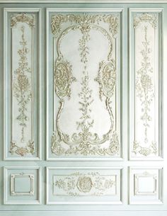 an ornate paneled room with white walls and gold trim