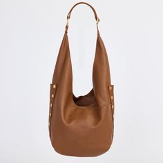 An updated version of everyone's favorite hobo bag has entered the chat; meet our updated Tom. With a zippered main compartment and adjustable strap, this shoulder bag still resembles the original, with pockets galore and a slouchy nature, making it extra roomy and the ultimate catch all bag. This leather features a soft pebbled texture with a hint of shine. Embrace the warm allure of this medium brown hue, enriched with a delicate yellow undertone that adds depth and sophistication to any ensemble. Crafted with a soft pebbled leather with a hint of shine featuring a warm medium brown hue Red logo twill lining Brushed gold hardware, functionality covered for life Exterior: side panels, crisscross drop pockets on front and back panels, adjustable shoulder strap with large O ring, slit detai Versatile Shoulder Bag With Snap Closure For On-the-go, Luxury Shoulder Bag With Snap Closure For On-the-go, Everyday Use Bucket Shoulder Bag With Gold-tone Hardware, Versatile Bucket Hobo Bag, Gold-tone Bucket Shoulder Bag For Daily Use, Everyday Crossbody Hobo Bag With Gold-tone Hardware, Modern Hobo Bag With Adjustable Strap, Hobo Bucket Bag With Adjustable Strap For Errands, Hobo Bag With Adjustable Strap For Errands