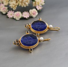 Description Gemstone - Indigo Blue Glass Material - Brass Gemstone Size - 13X18 mm Earring Height Including Hoop - 4.5 cm Earring Width - 2.5 cm Finish - Smooth and high polished with brilliant shine Note -The earrings are made to order, production day is about 3-5 working days. The one you receive may be slight different from the one in the picture due to handmade nature, but it will be almost same as in the above picture.These pieces are handcrafted from start to finish and have an imperfect h Blue Pendant Earrings For Wedding, Blue Gemstone Pendant Earrings, Blue Pendant Earrings For Gift, Blue Round Clip-on Jewelry, Blue Clip-on Earrings For Gift, Blue Clip-on Earrings For A Gift, Handmade Sapphire Round Earrings, Blue Round Plug Earrings As Gift, Blue Round Plug Earrings For Gift